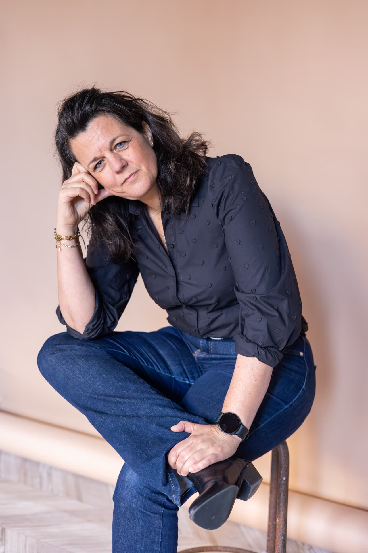 Mathilda van den Hof zittend tegen een zachtroze achtergrond