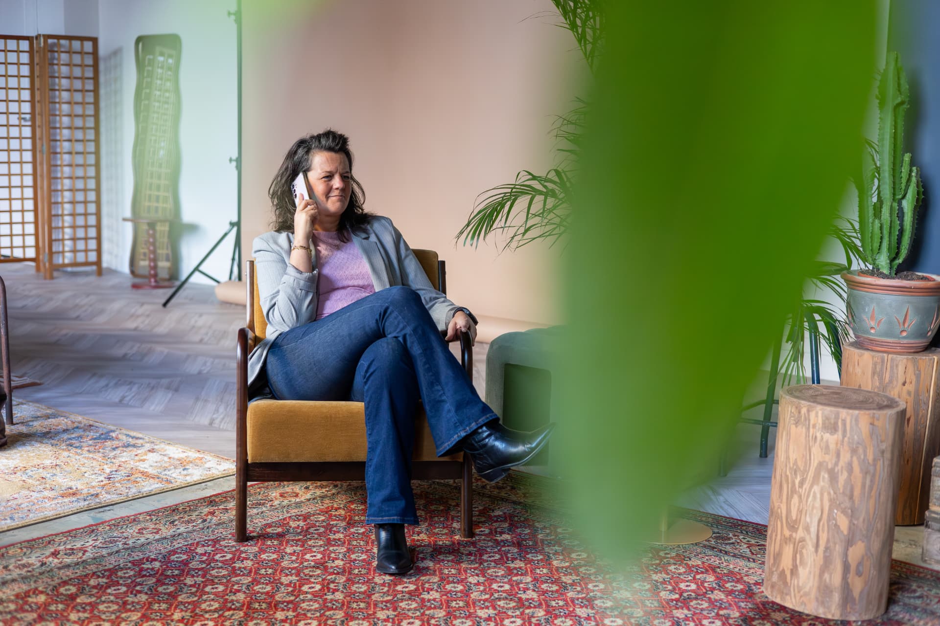 Mathilda van den Hof voert zittend in een stoel een telefoongesprek